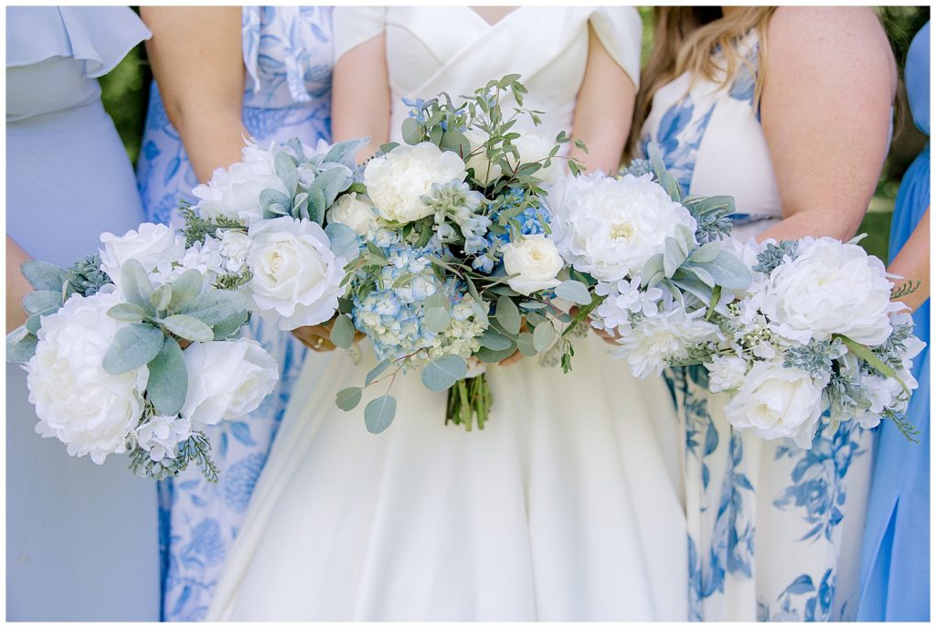 bride and bridesmaids all holding their blue and white bouquets next to each other at a Georgetown Kentucky wedding.